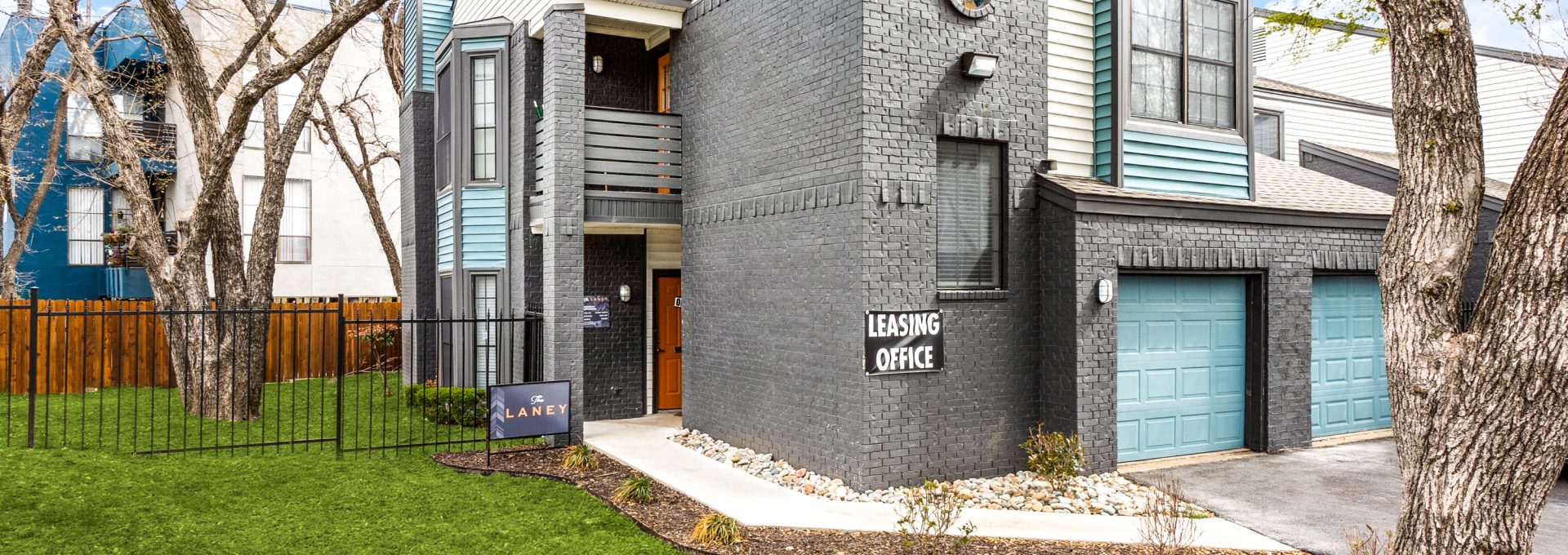 the front of a two story apartment building with a garage at The  Laney