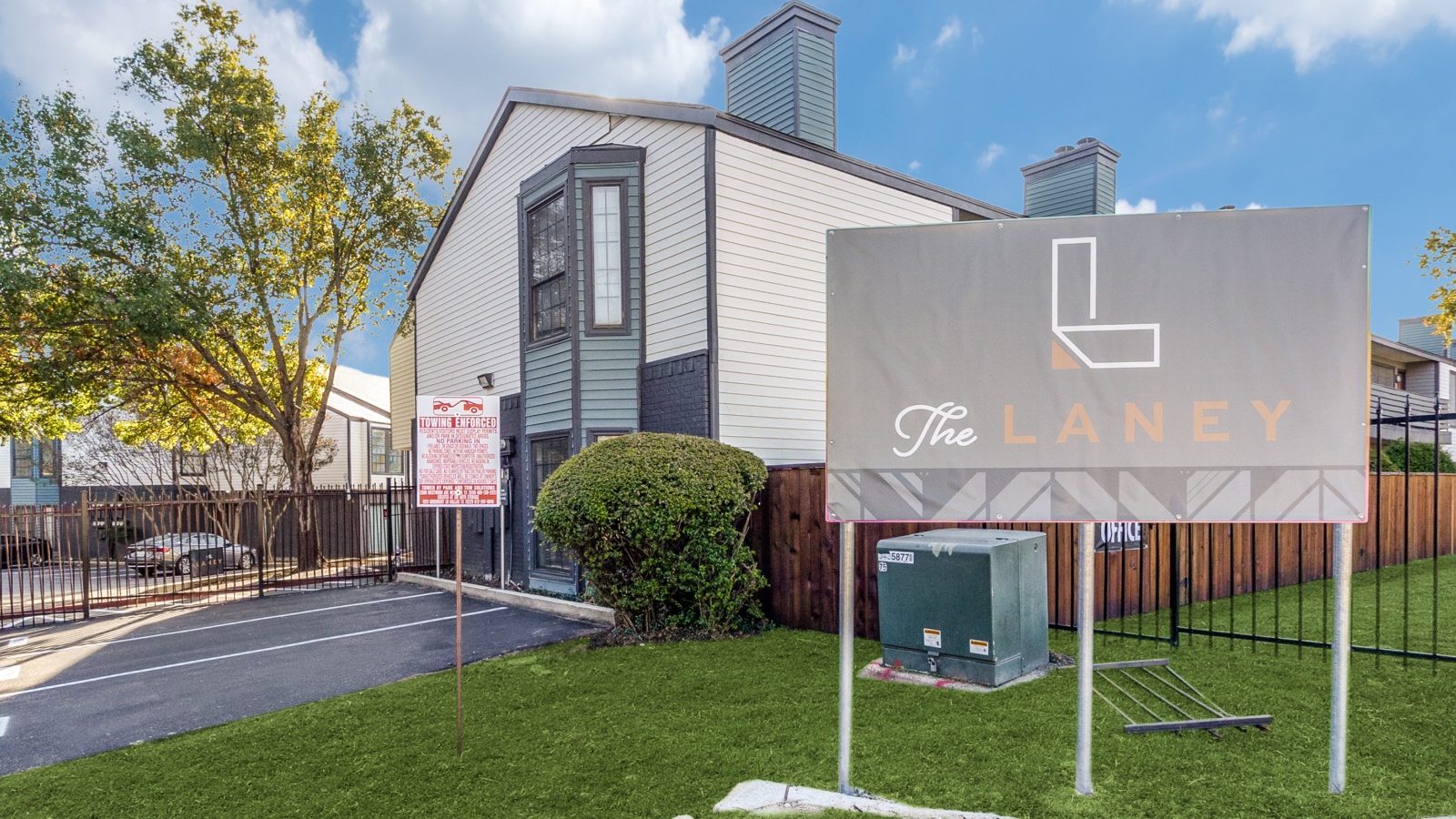 the sign for the apartment complex is in front of a grassy area at The  Laney