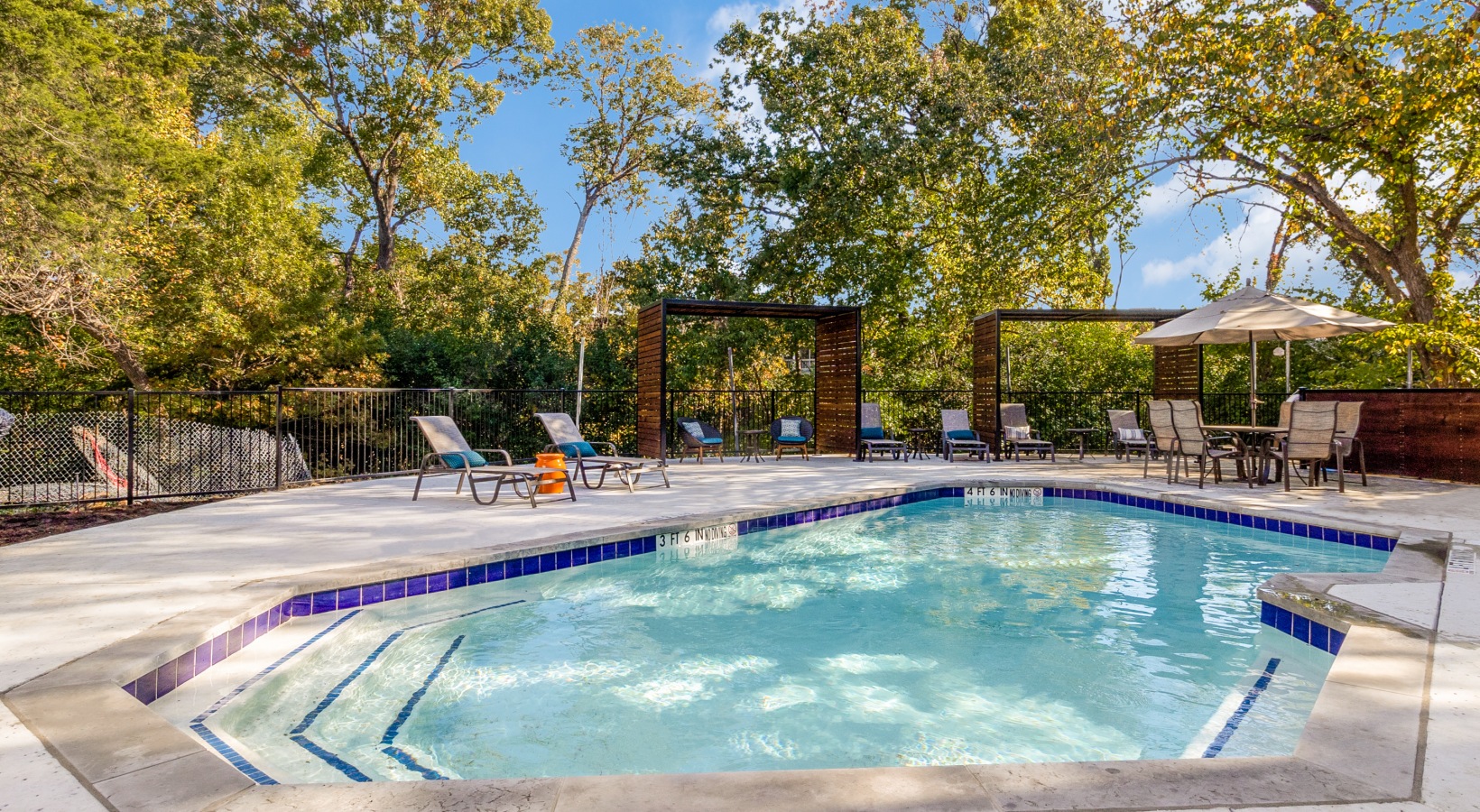 a pool with a patio and chairs around it at The Laney