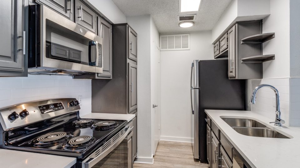 kitchen with stainless steel appliances and black cabinets at The  Laney