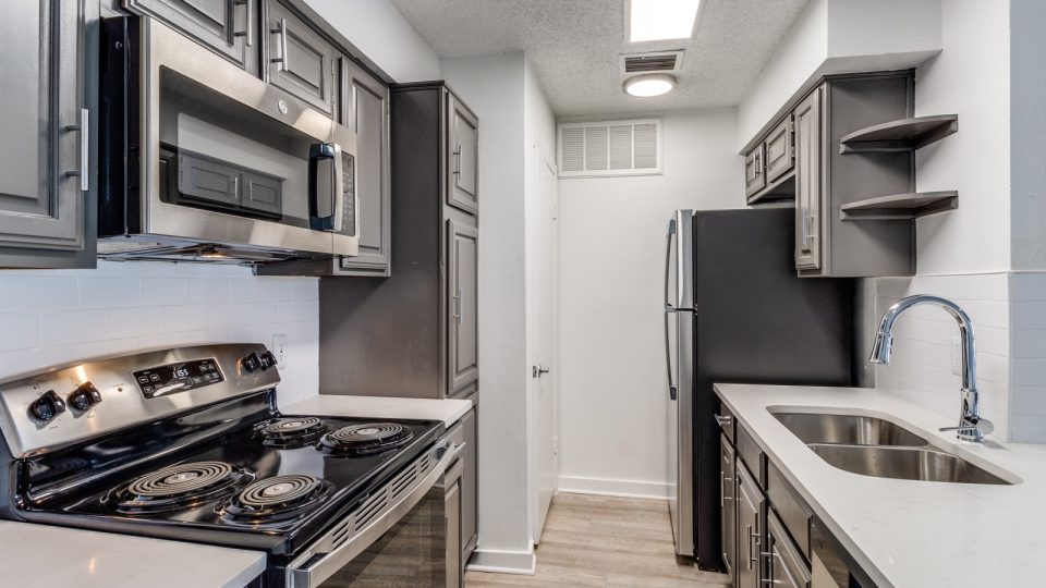 kitchen with stainless steel appliances and black cabinets at The Laney