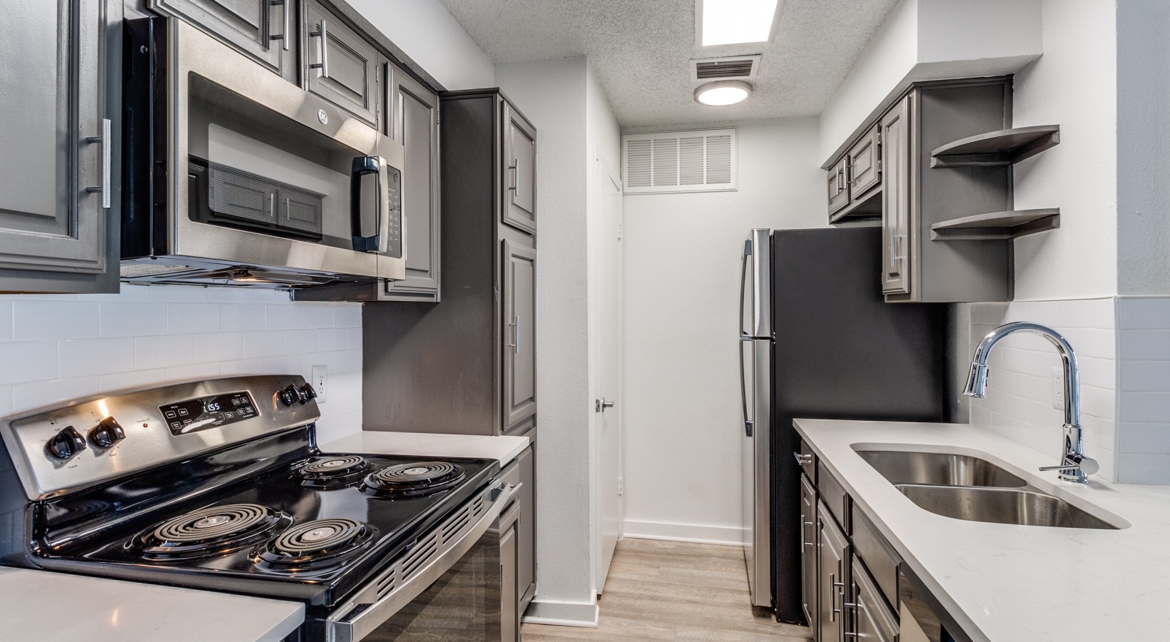 kitchen with stainless steel appliances and black cabinets at The Laney